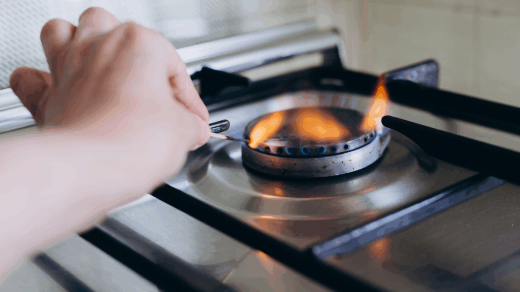 Une personne qui allume le gaz avec une allumette