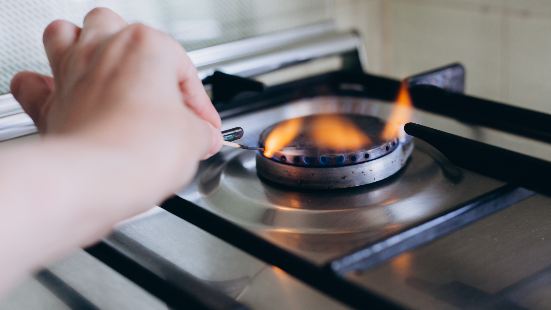 Une personne qui allume le gaz avec une allumette